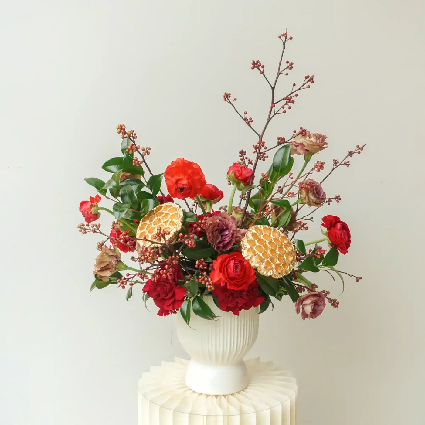 red-and-gold-christmas-flower-arrangement-on-white-vase