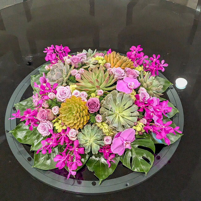 Beautiful floral centerpiece with succulents and vibrant pink blooms.