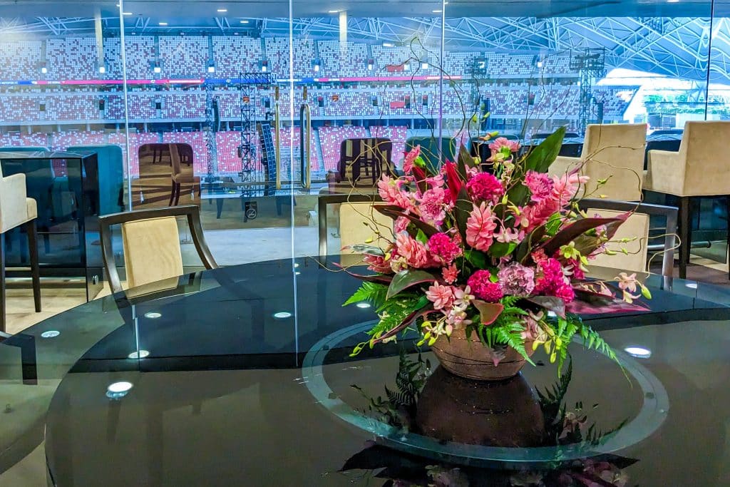 Elegant floral centerpiece with pink roses and greenery for corporate event decor.