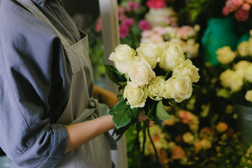 White roses symbolize purity and remembrance in funeral floral arrangements.