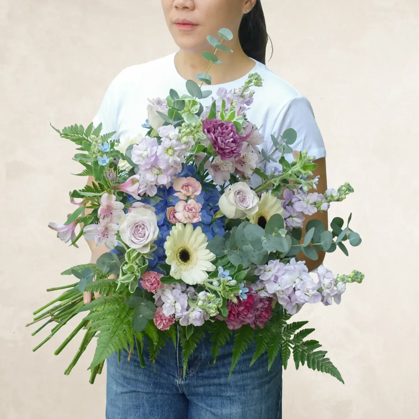 Elegant bouquet featuring pastel roses, daisies, and greenery for a serene and graceful look.