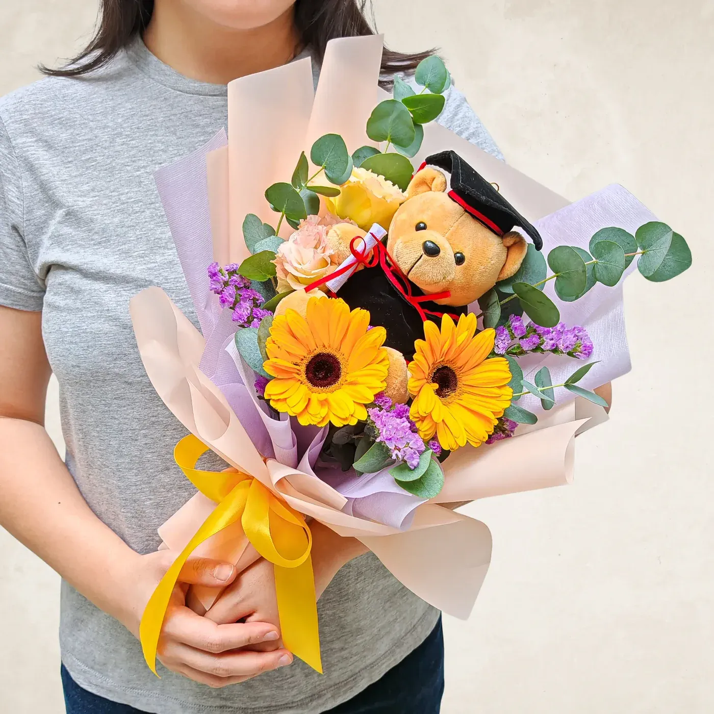 Cute graduation teddy with floral bouquet.