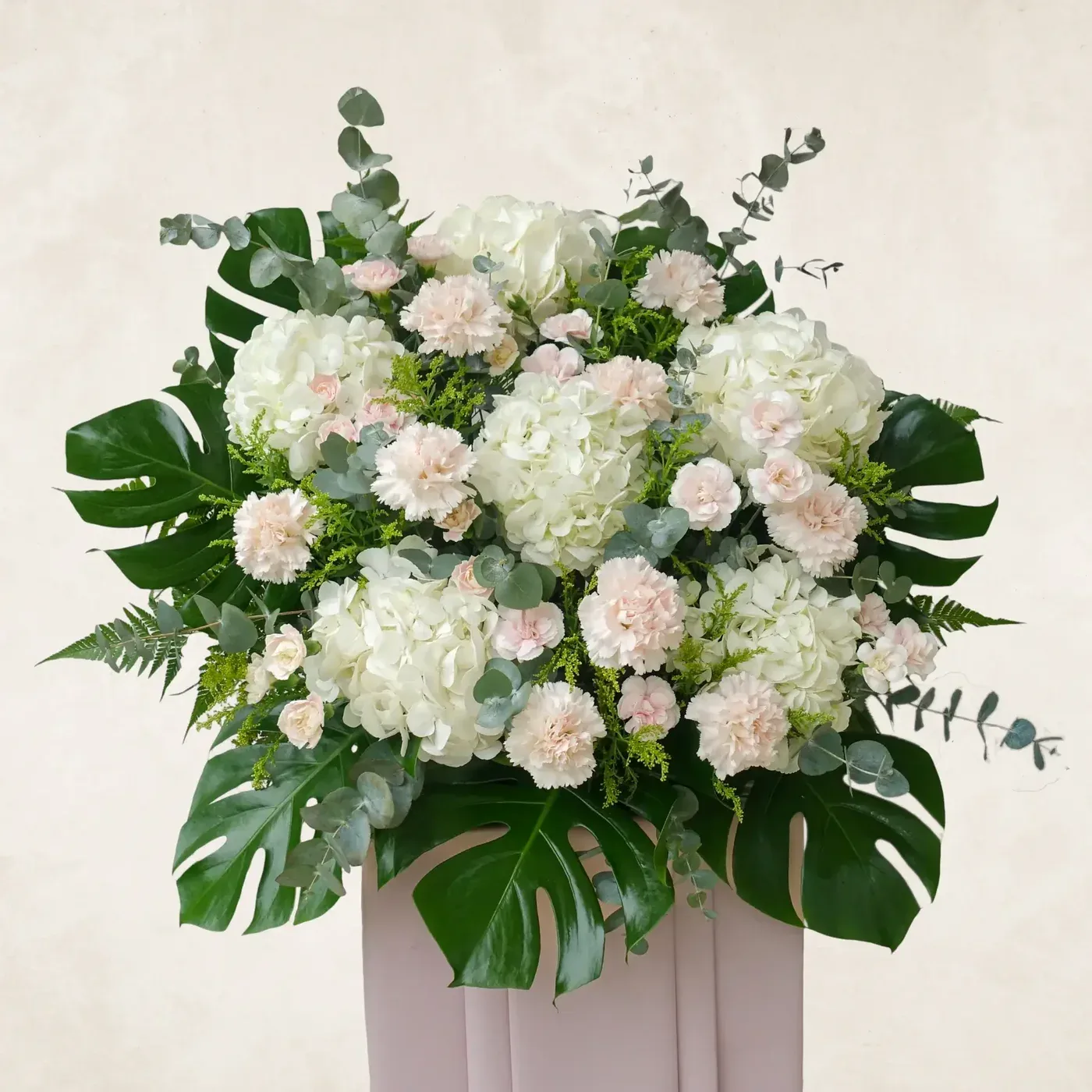 Elegant white and pink floral arrangement with lush greenery for a peaceful resting space.