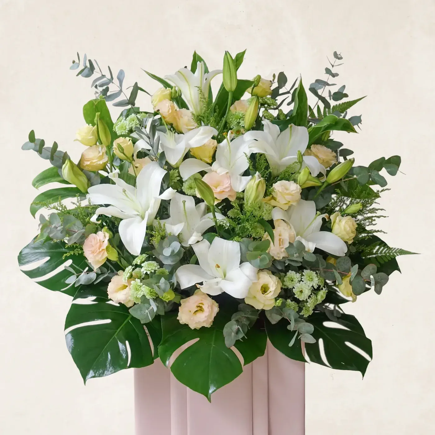 Beautiful white lilies, roses, and greenery in a stylish floral display. Perfect for a serene and gr.
