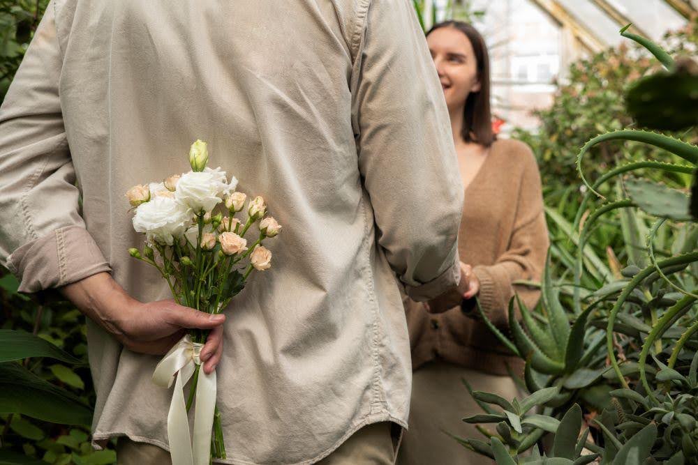 Man giving apology flowers to girlfriend in a floral studio setting.